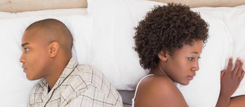 man and woman angry on bed away from each other