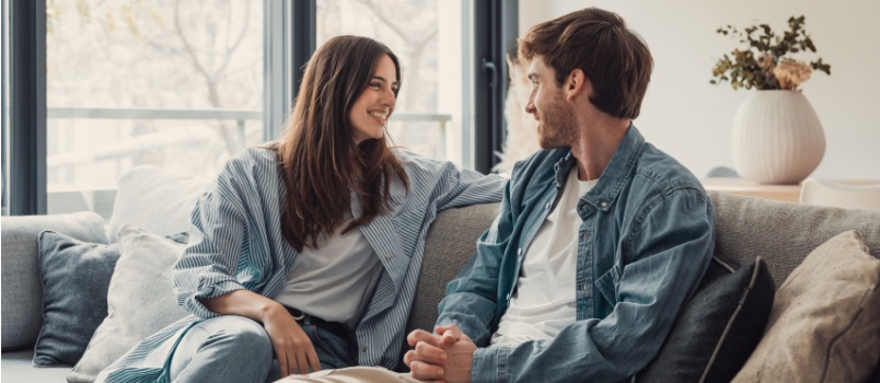 Couple talking while sitting together on the sofa
