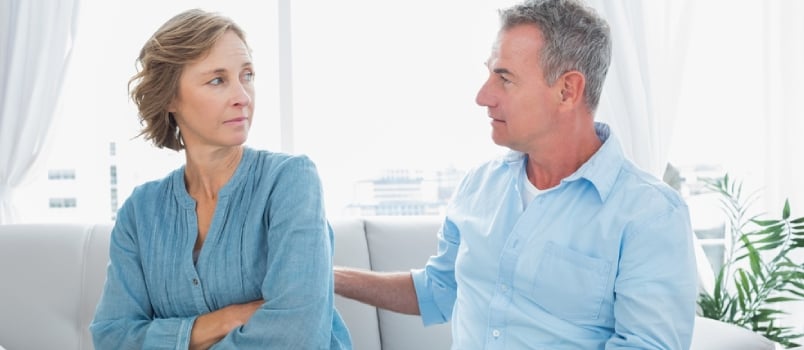 Middle Aged Couple Sitting On The Sofa Having A Dispute At Home In The Living Room