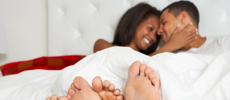 Couple Relaxing in Bed Wearing Pajamas