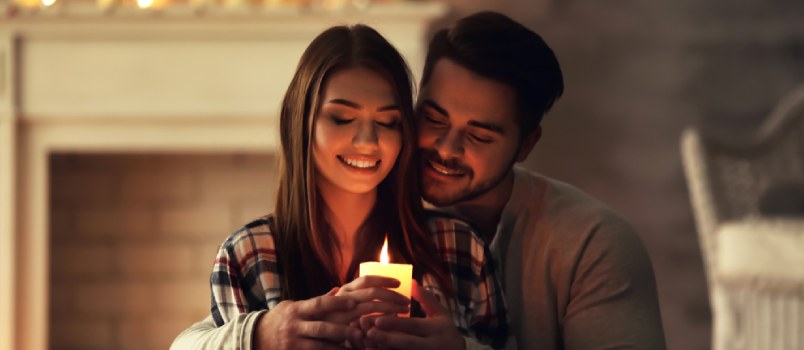 man and woman happy holding a candle