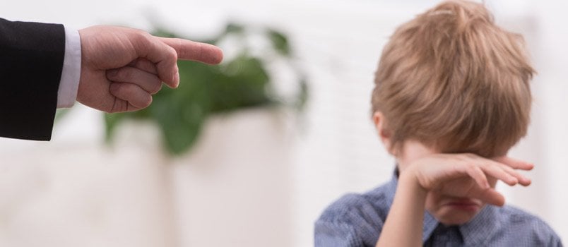 Man Pointing Finger On The Boy While Boy Is Crying And Cleaning His Face