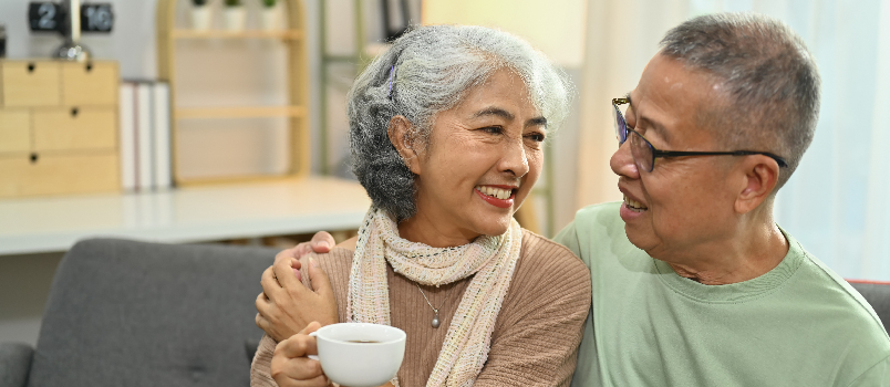 Couple de personnes âgées souriant et se relaxant à la maison