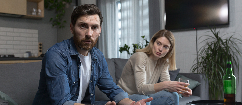 Upset Man with Woman Sitting on Couch