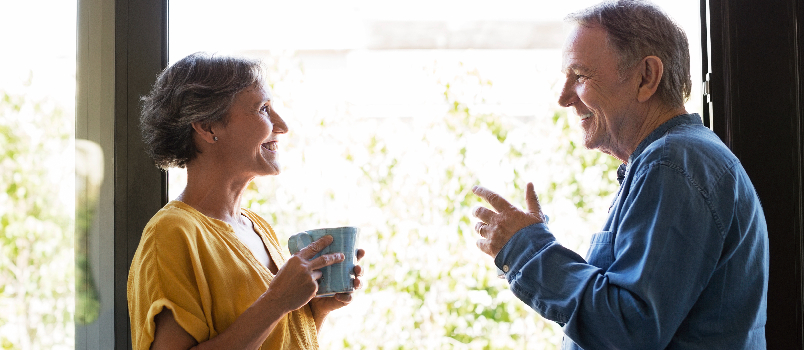 Couple de personnes âgées partageant une conversation heureuse à la maison