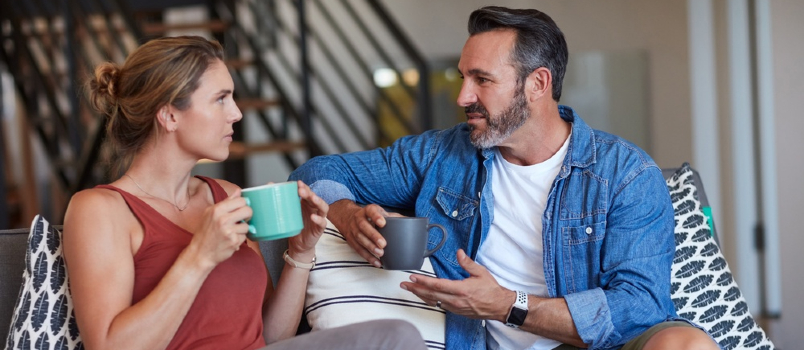 couple relaxing on couch having coffee