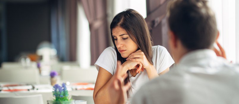 sad woman sitting across a table