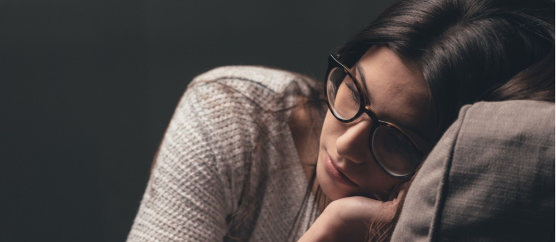 Sad woman laying on couch