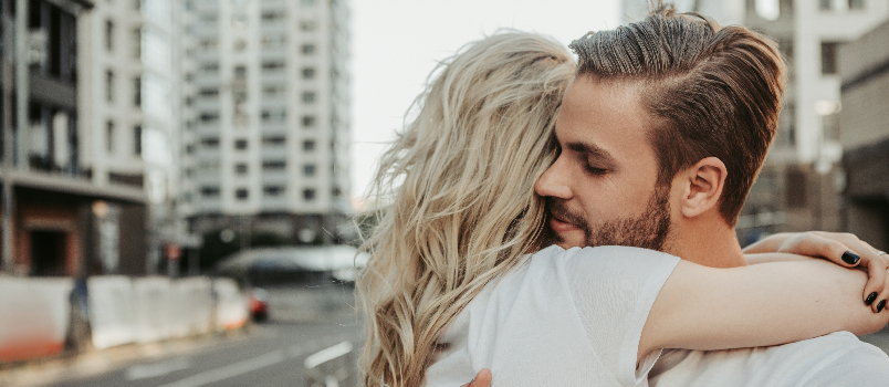 Una pareja amorosa se abraza en una bulliciosa calle de la ciudad