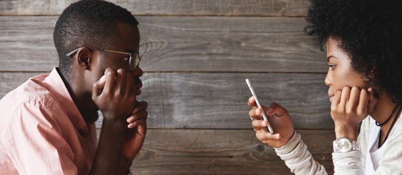 Couple using their mobile phone