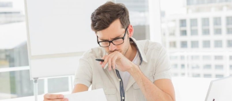 worried man looking at papers