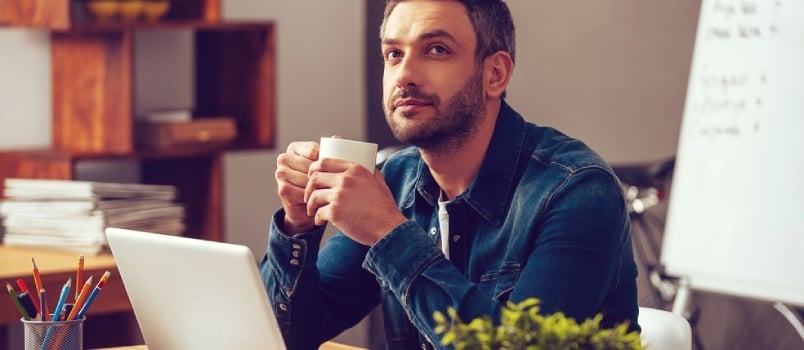 man sitting and drinking coffee while thinking