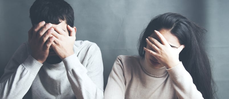 sad young couple sitting together