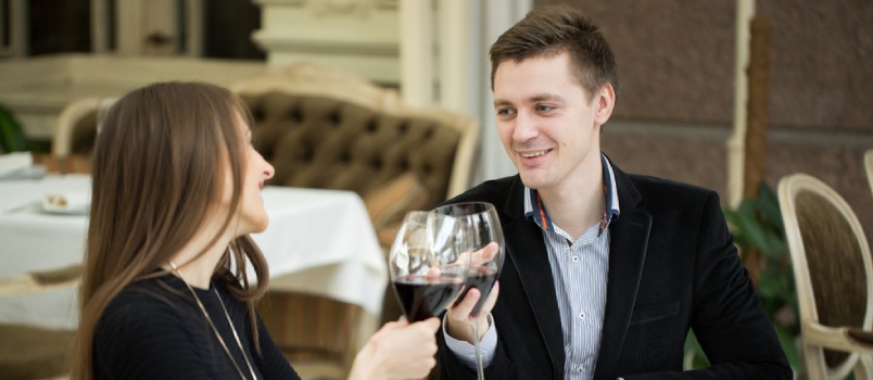 White man and woman celebrating by drinking wine