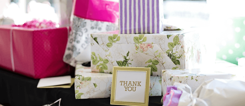 Wrapped presents kept on table with thank you note