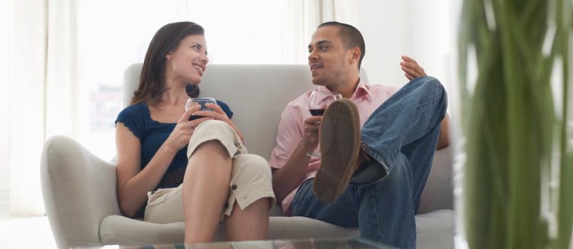 happy couple sitting on couch and talking