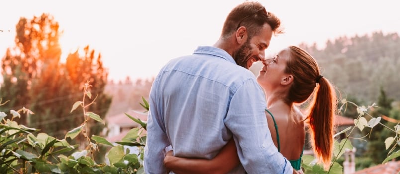 White man and woman standing together looking at each other