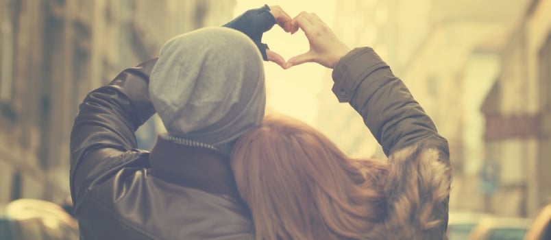 Man and woman bringing hands together to make a heart