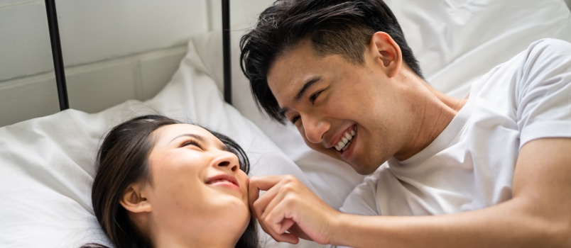 Newly married couple laying on bed