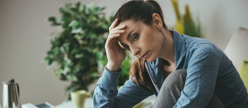 Sad woman sitting with her head in her hands
