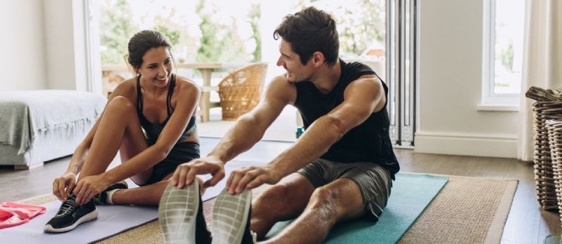 young couple smiling while exercising together