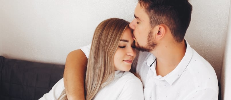 Loving couple have fun at home. Pretty blonde in a white blouse.