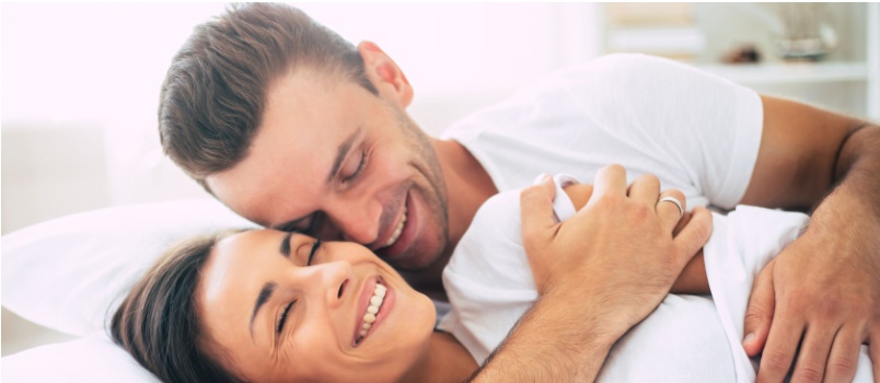 Young cute couple laying on bed