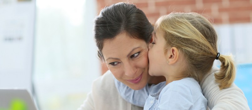 Young girl kissing mom on the cheek