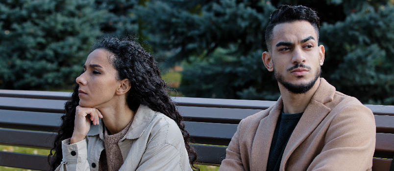 Couple Sitting on Park Bench in Thought