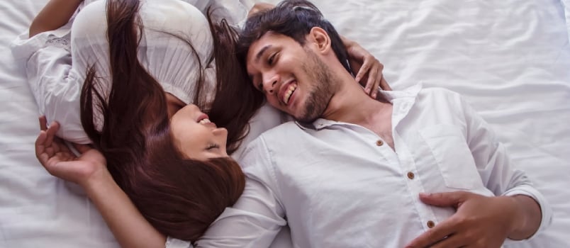 couple lying on bed and smiling