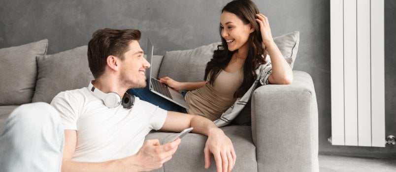 Cheerful Happy Couple Is Doing Online Shopping In Internet At Home Indoors