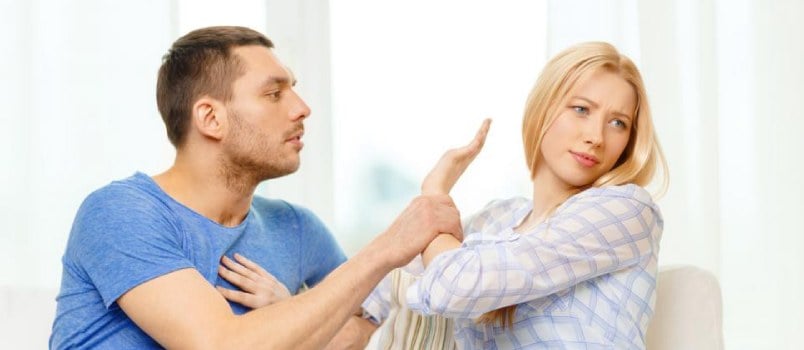 Man and woman fighting while sitting on the couch