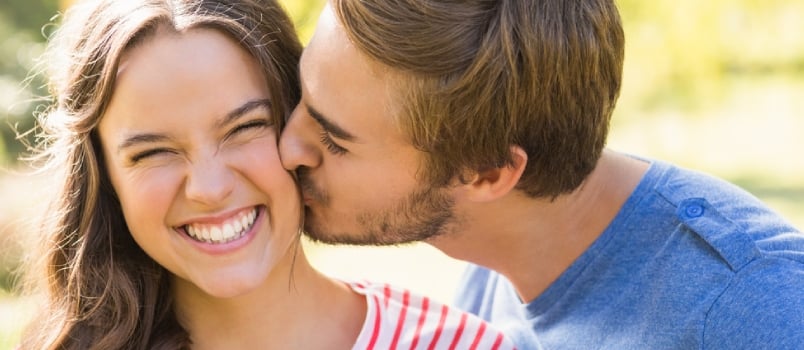 Cute Couple Kissing in the Park on a Sunny Day