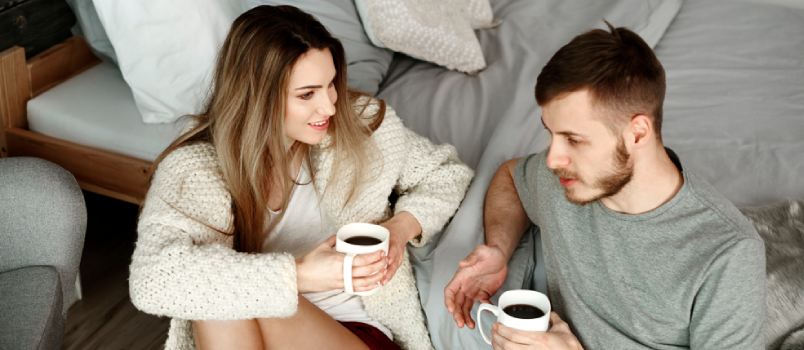 couple talking with coffee in hand