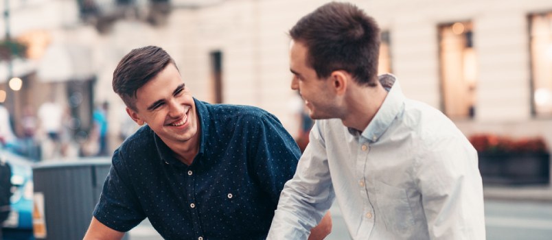 two men talking and smiling
