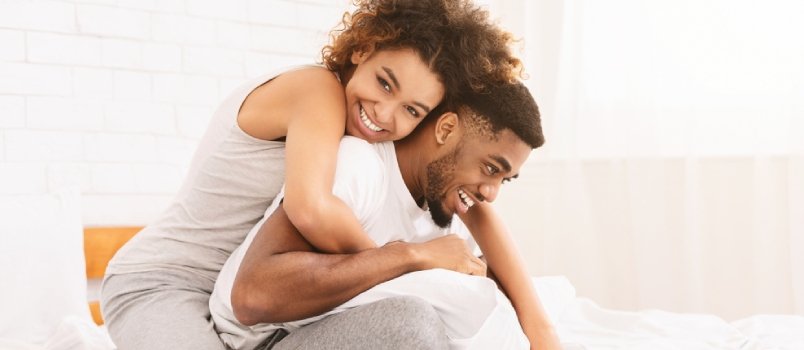 black couple cuddling in bed