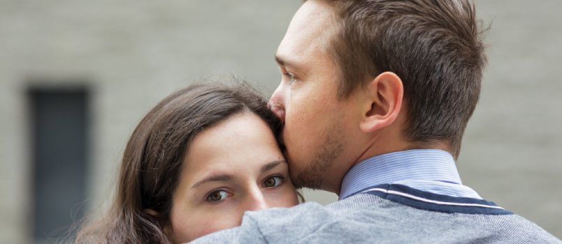 man hugging a scared woman