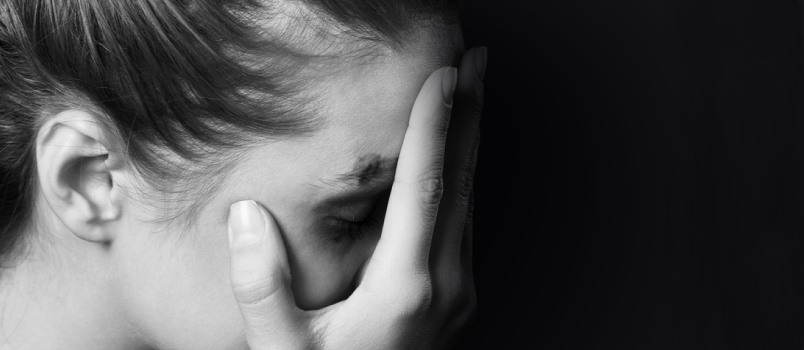 black and white image of a woman with hands covering her face