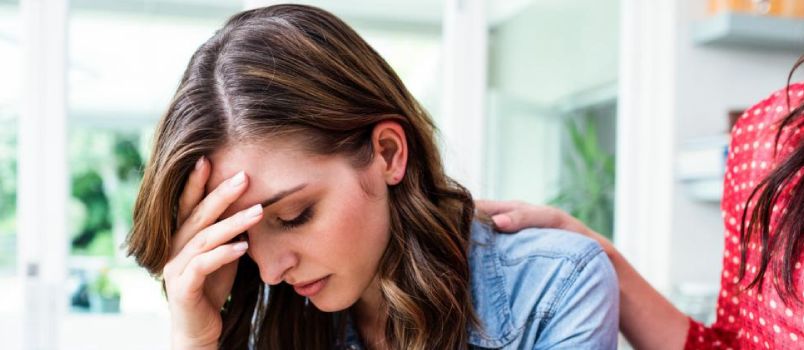 white woman sad with head in her hands