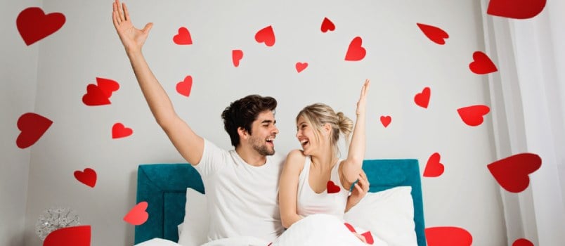 Couple On Bed At Bedroom In The Blanked With Heart-shape Background Desing