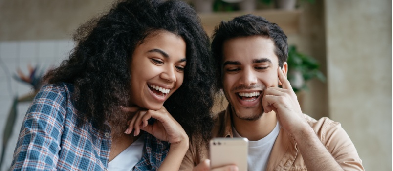 Happy couple using smartphone