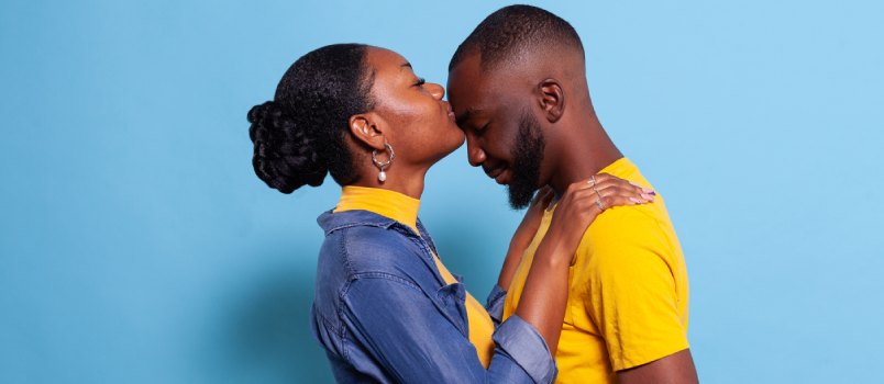 Woman kissing on man forehead