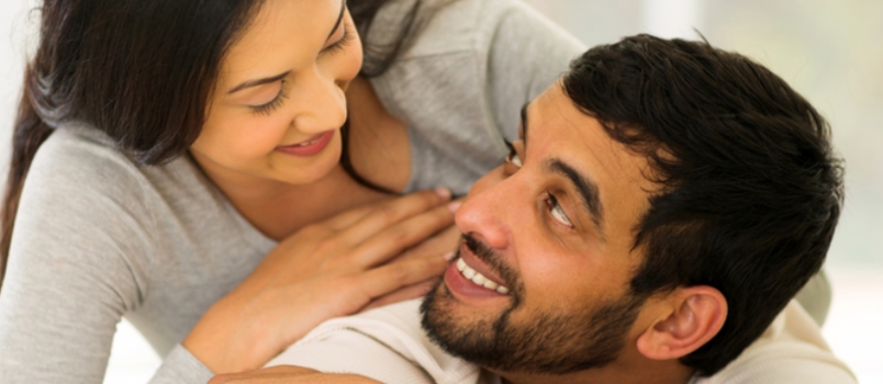Portrait of Loving Indian Couple Lying on Bed at Home