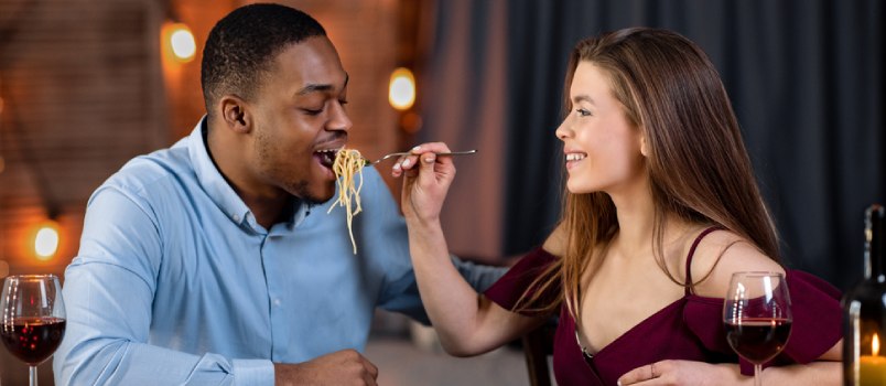 woman feeding food to her boyfriend