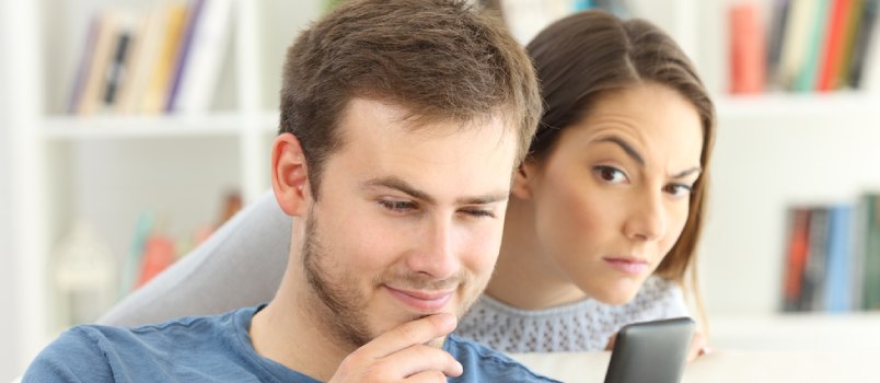 woman looking into her boyfriend's phone