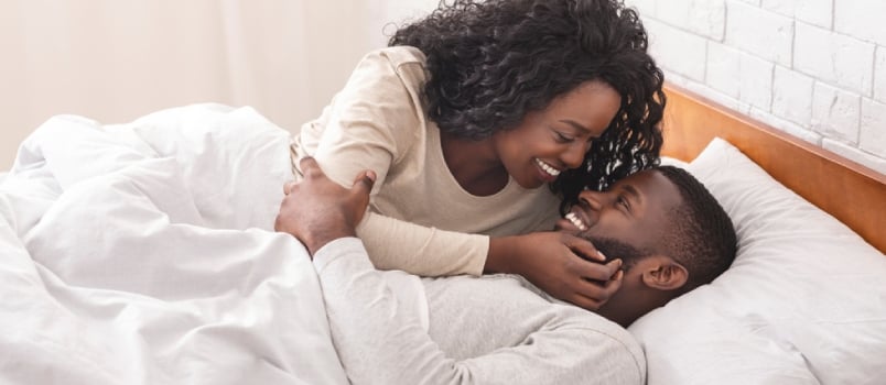 African men and women on bed in love