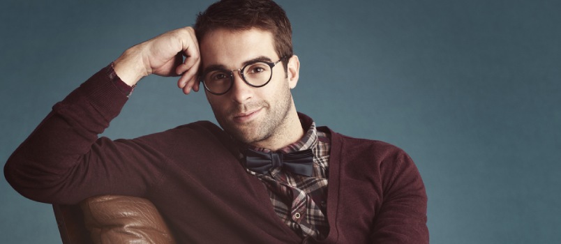 a man wearing glasses and smiling