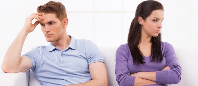 Couple sitting on a couch facing in opposite directions