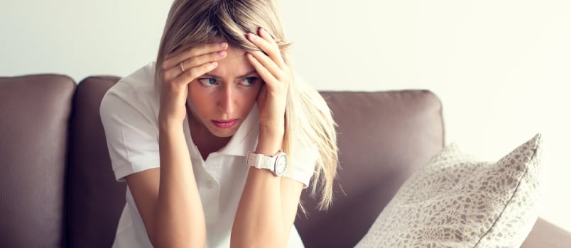 Stressed woman sitting with her head in her hands