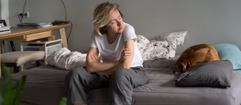 Single lady sitting on bed alone